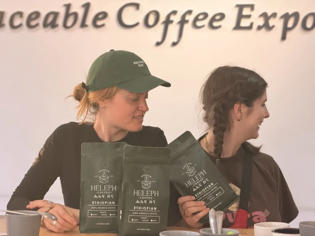 Visitor in Heleph cap holding coffee bags