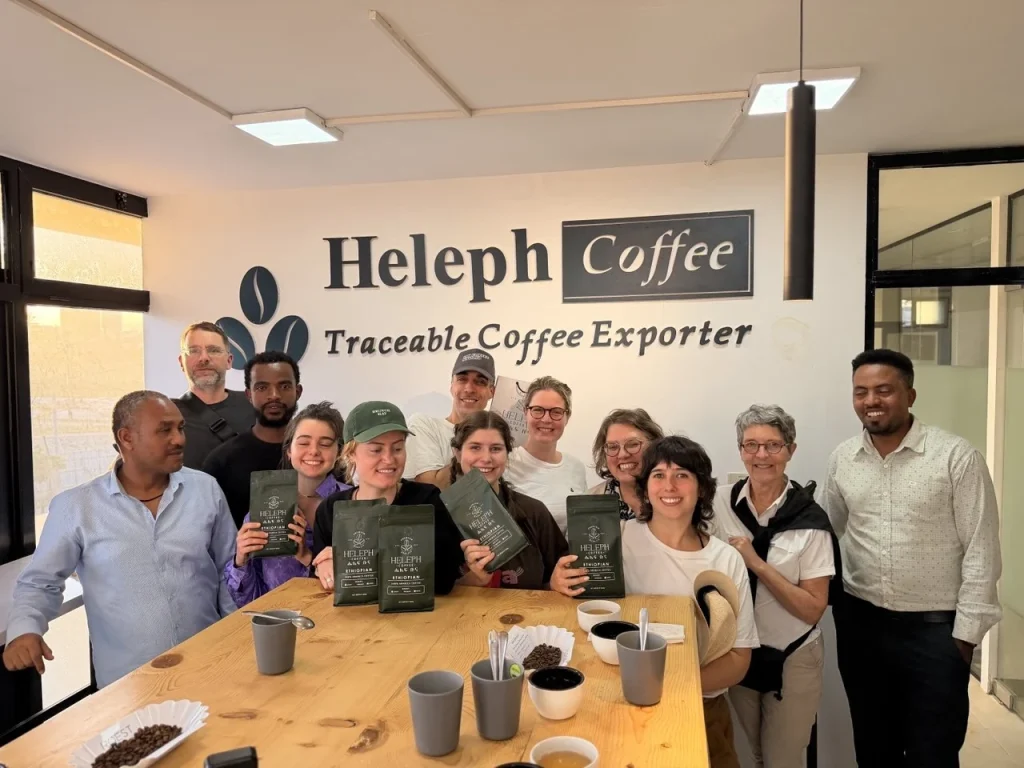 Visitors and Heleph team holding coffee bags after cupping