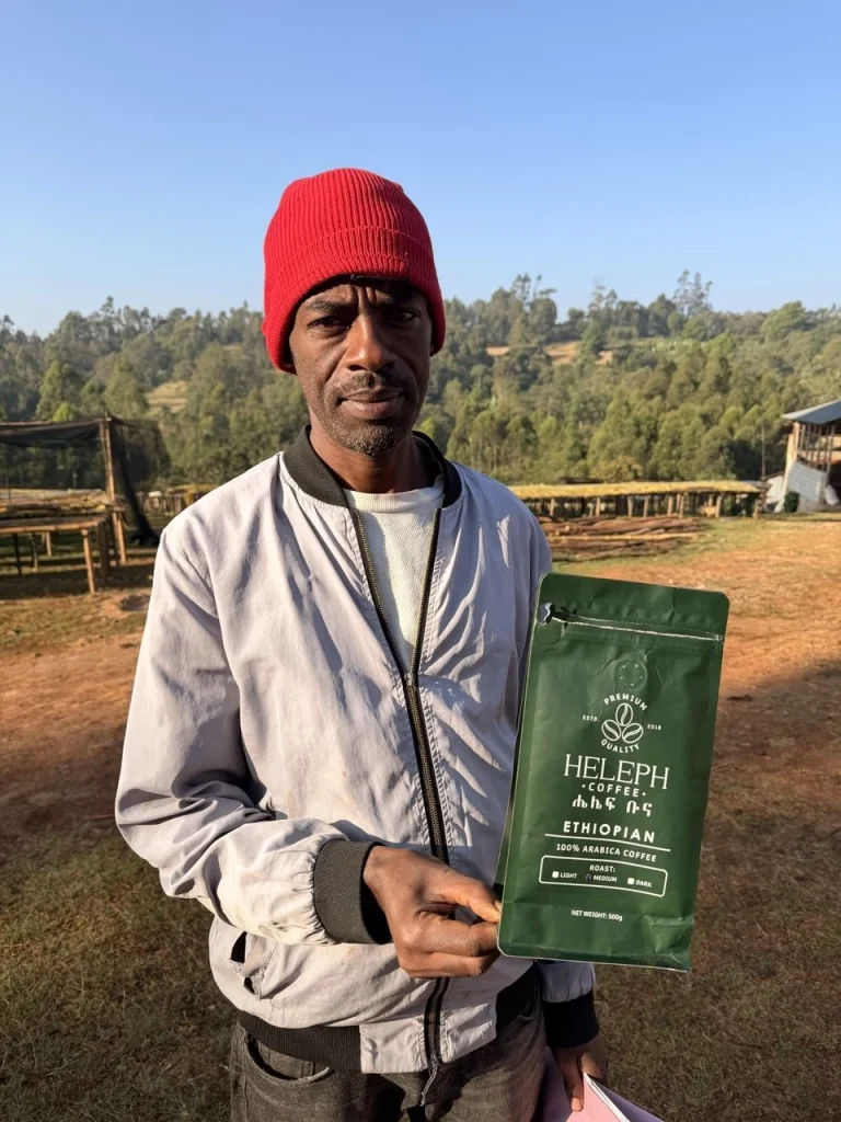 Ethiopian coffee farmer holding a Heleph coffee bag
