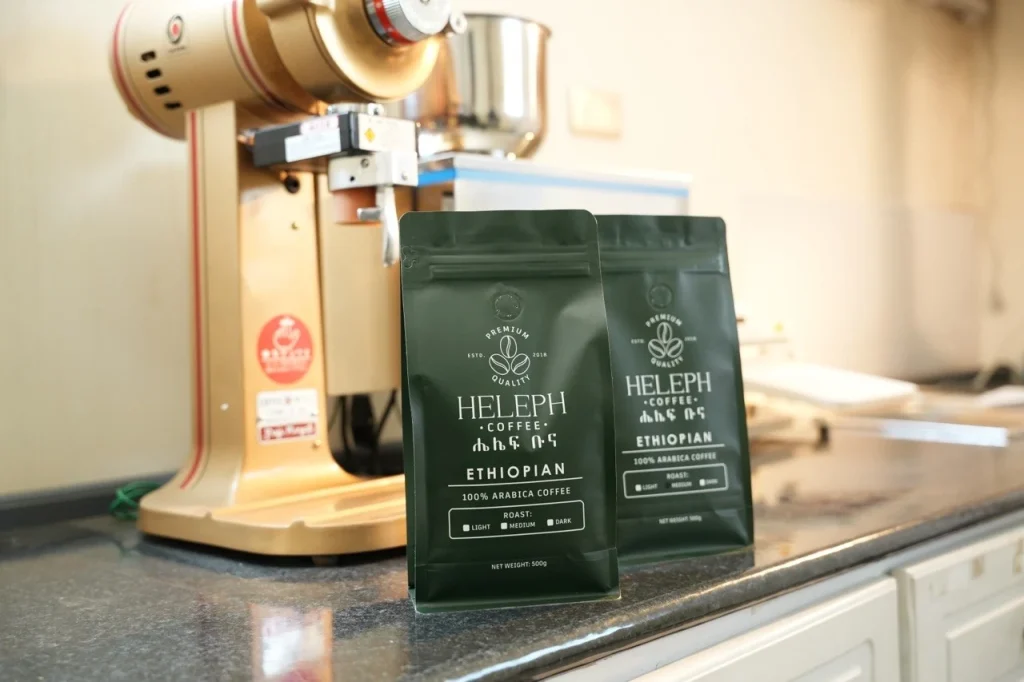 Heleph Ethiopian coffee bags next to a coffee grinder