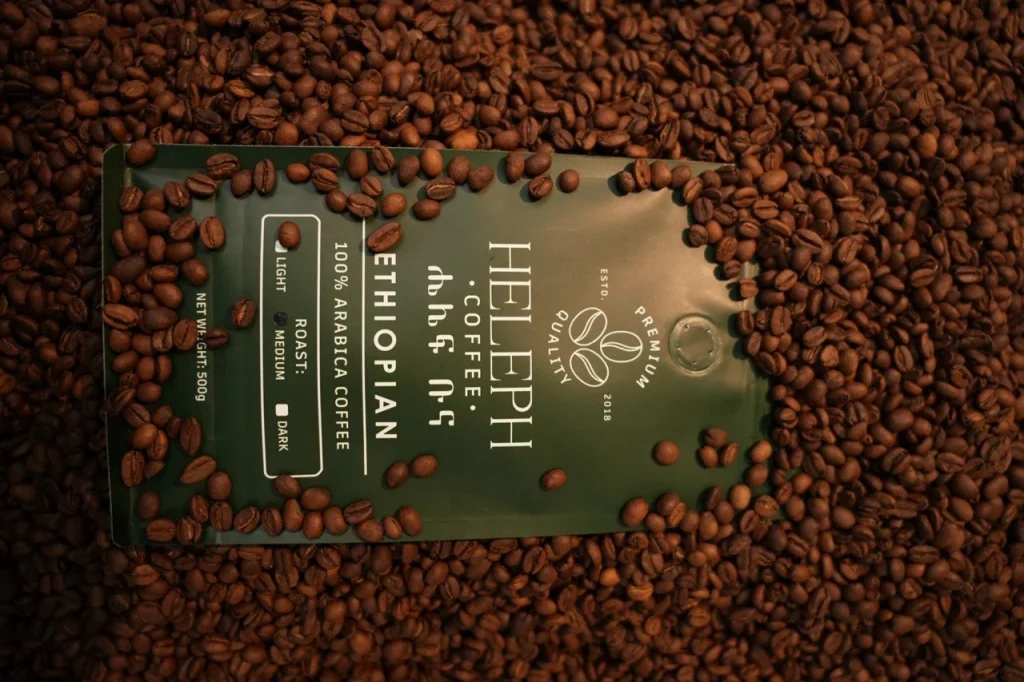 Heleph 100% Arabica bag laid on roasted beans
